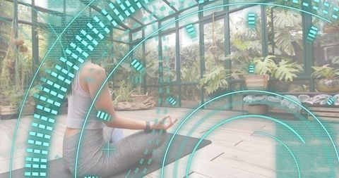 Woman meditating in glass greenhouse with futuristic hud overlay for wellness tech