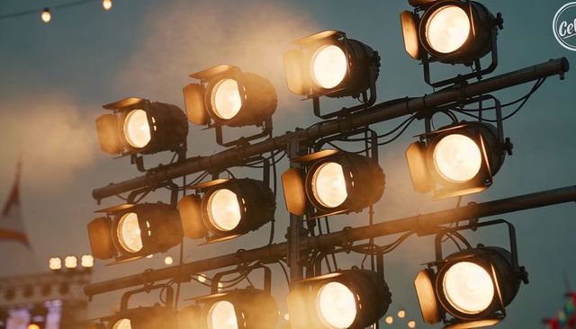 Shining Stage Spotlights Casting Amber Haze on Outdoor Truss Lighting Rig at Dusk