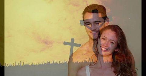 Smiling couple embracing in double exposure with crosses and golden sunset glow