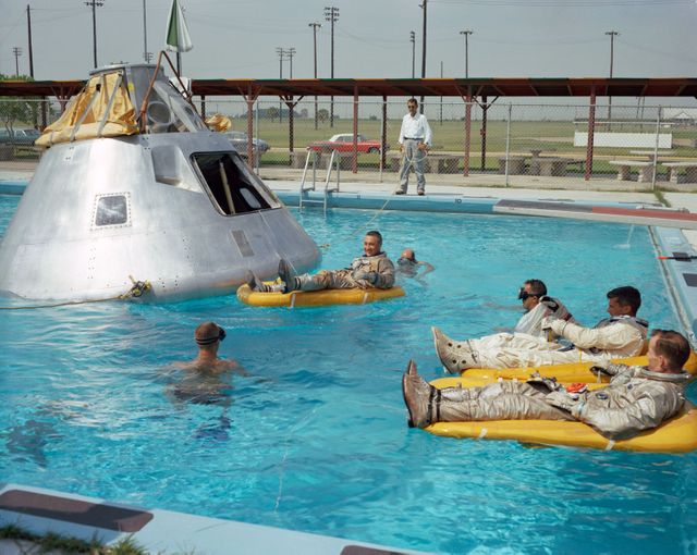 S66-51581 (June 1966) --- Prime crew for the first manned Apollo mission practice water egress procedures with full scale boilerplate model of their spacecraft. In the water at right is astronaut Edward H. White (foreground) and astronaut Roger B. Chaffee. In raft near the spacecraft is astronaut Virgil I. Grissom. NASA swimmers are in the water to assist in the practice session that took place at Ellington AFB, near the Manned Spacecraft Center, Houston.