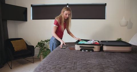 Teen girl packing suitcase for adventure vacation