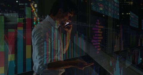 Business analyst examining data with digital charts in office at night