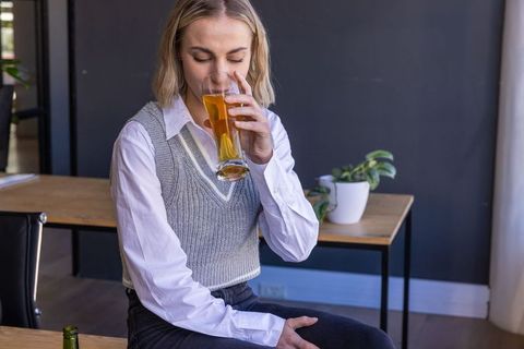 Woman relaxing with beverage in cozy home office setting