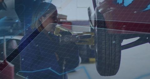 Female mechanic tightening wheel with impact wrench on lifted car with digital overlay
