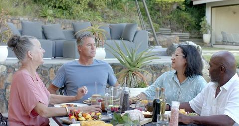 Diverse Friends Sharing Meal on Backyard Patio Gathering Party