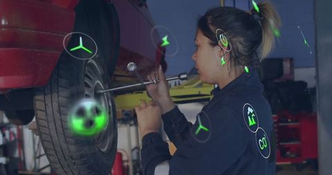 Female mechanic working on vehicle tire in auto garage