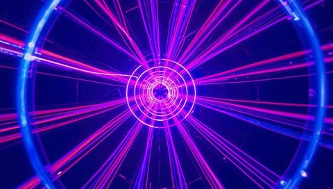 Neon Concentric Rings Radiating Magenta Beams Through Futuristic Light Tunnel