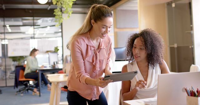 Two Female Colleagues Collaborating on Tablet in Modern Office - Download Free Stock Images Pikwizard.com