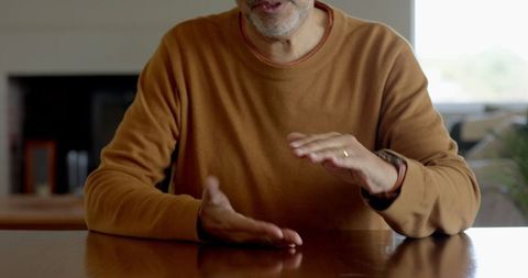 Senior Man Gesturing While Talking at Home Table - Download Free Stock Images Pikwizard.com