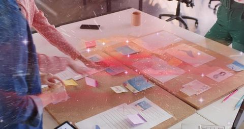 Women Collaborating on UX Wireframes with Sticky Notes on Corkboards in Open Office