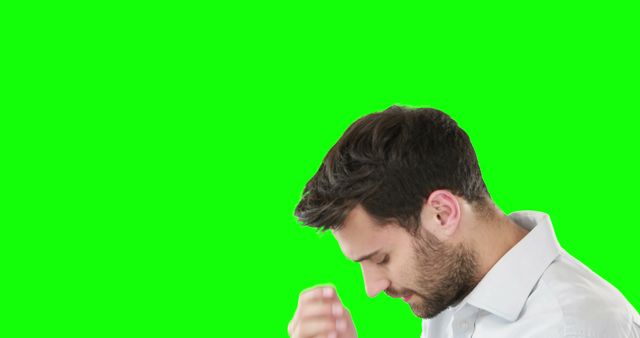 A young man in a white shirt shown from the side, appearing deep in thought, with a green background. Ideal for use in advertising, mental health campaigns, design mock-ups, or any scenario requiring a feeling of contemplation or decision-making.