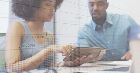 Multicultural Team Analyzing Data on Digital Tablet in Modern Office