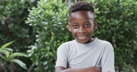 Confident African American Boy Smiling in Lush Greenery