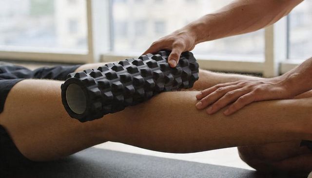 Foam roller rolling over athlete thigh during myofascial release and recovery session
