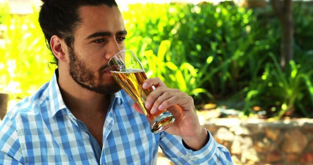 Man Drinking Beer Outdoors in Sunlit Garden - Download Free Stock Images Pikwizard.com