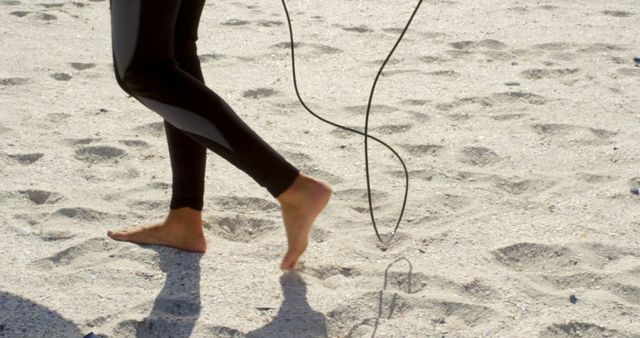 Person skipping rope on the beach, with copy space. Outdoor exercise by the sea promotes a healthy lifestyle and relaxation.
