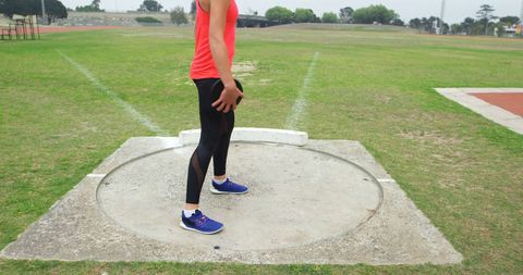 Female Athlete Preparing for Discus Throw Outdoors