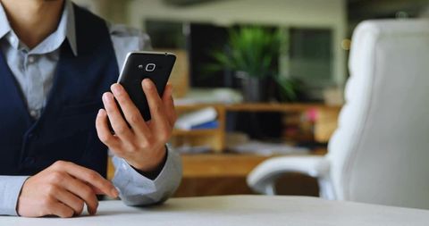 Professional Holding Smartphone in Modern Office Space
