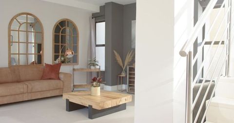 Tan leather sofa anchoring modern living room with thick reclaimed wood coffee table