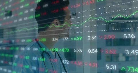 Male Doctor in Scrubs Reflecting on Healthcare Data with Financial Market Tickers Overlay