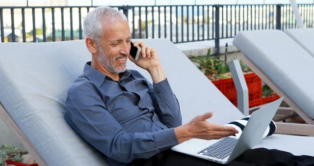 Mature Businessman Enjoying Outdoor Work on Laptop While Talking on Phone - Download Free Stock Images Pikwizard.com