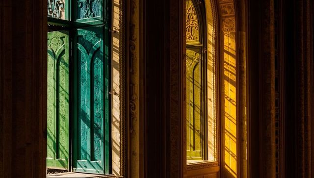 Colorful arched windows with intricate shadows in historic hall