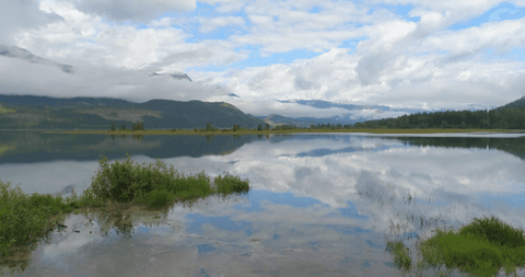 scenic transparent lake reflection of clouds and mountains - Download Free Stock Videos Pikwizard.com