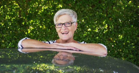 Smiling Senior Woman Enjoying Sunny Day Outdoors by Car