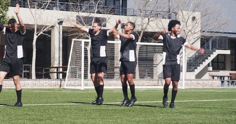 Energetic soccer team warming up with dynamic exercises outdoors