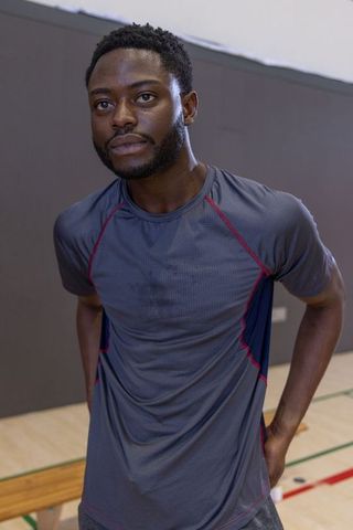 African american athlete standing leaning on gym bench showing focus and determination