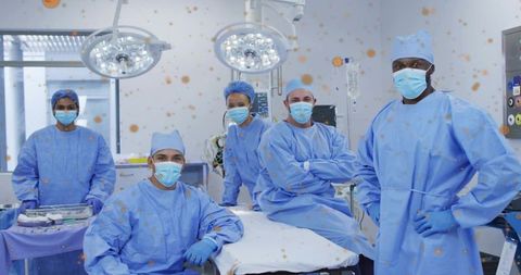 Surgical team building teamwork in sterile operating room under surgical lights