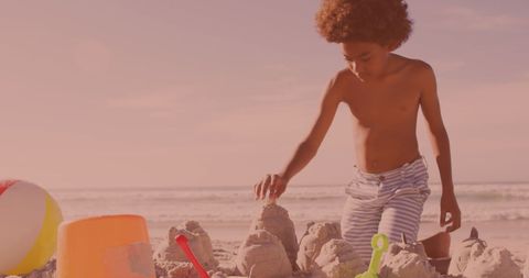 Young Boy Building Sandcastles on Sunny Beach