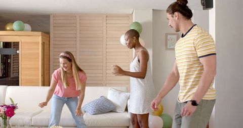 Friends Decorating Living Room with Balloons for Festive Celebration