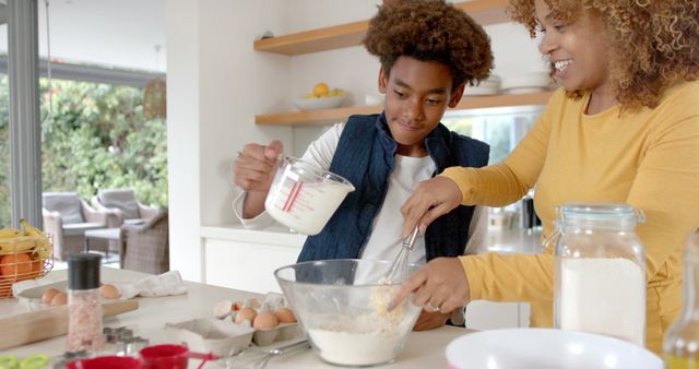 African American boy and mother baking together in modern kitchen - Download Free Stock Images Pikwizard.com