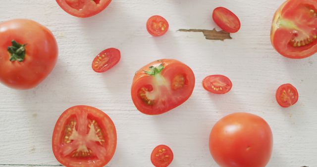 Variety of tomatoes displayed on white wooden background. Useful for food blogs, recipes, nutrition articles, advertisements for fresh produce, and health-focused content.