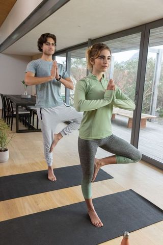 Couple Practicing Yoga in Modern Interior for Harmony and Balance