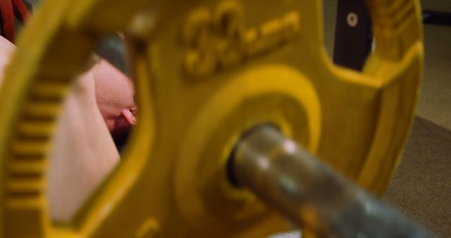 Bench pressing with yellow weight plate in gym - Download Free Stock Images Pikwizard.com