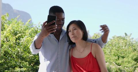 Diverse Professionals Collaborating on Smartphone Outdoors