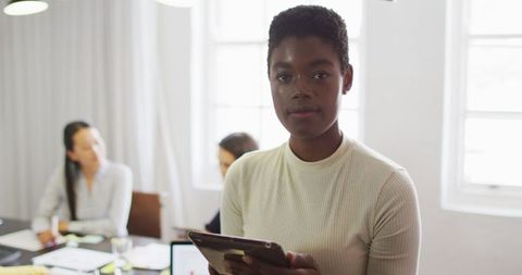Confident Businesswoman Leading Office Presentation with Tablet