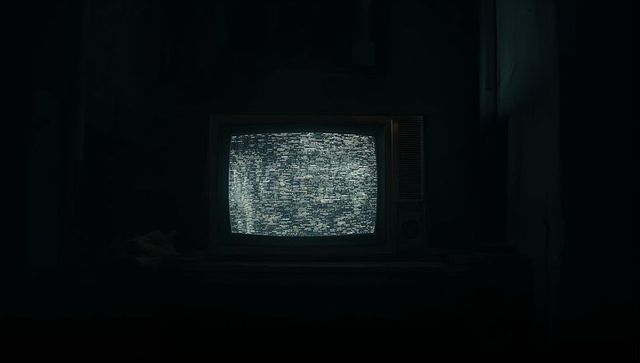 Vintage crt tv emitting static in dim room corner