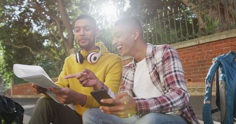 Two Friends Utilizing Smartphone and Map During Urban Exploration