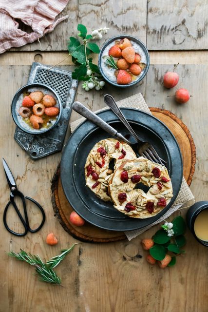 A rustic breakfast table featuring bagels with fruit toppings and fresh berries. The wooden surface provides a cozy ambiance. This image can be used for food blogs, recipe websites, marketing materials for cafes, or kitchen decor inspiration.