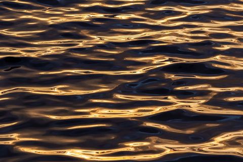 Golden Hour Ripples on Dark Water Abstract Shimmering Sunset Reflections Pattern