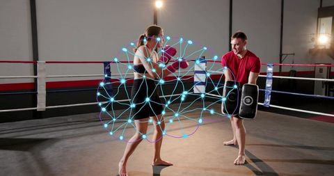Female boxer training with coach holding focus pads, neural network overlay in boxing ring