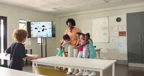 African American Teacher Embracing Smiling Elementary Students in Bright Classroom, Joyful Learning