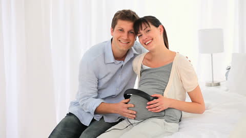 Expectant Couple Enjoying Music Together with Unborn Baby