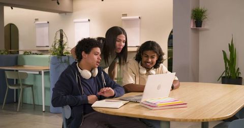 African American students collaborating at laptop in shared study and coworking space