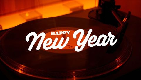 Spinning vinyl turntable with happy new year graphic and warm amber backlight