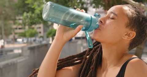 Young Woman Hydrating in Urban Environment with Water Bottle - Download Free Stock Images Pikwizard.com