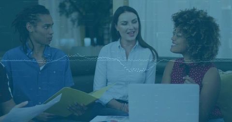 Diverse Professionals Collaborating on Laptop and Documents